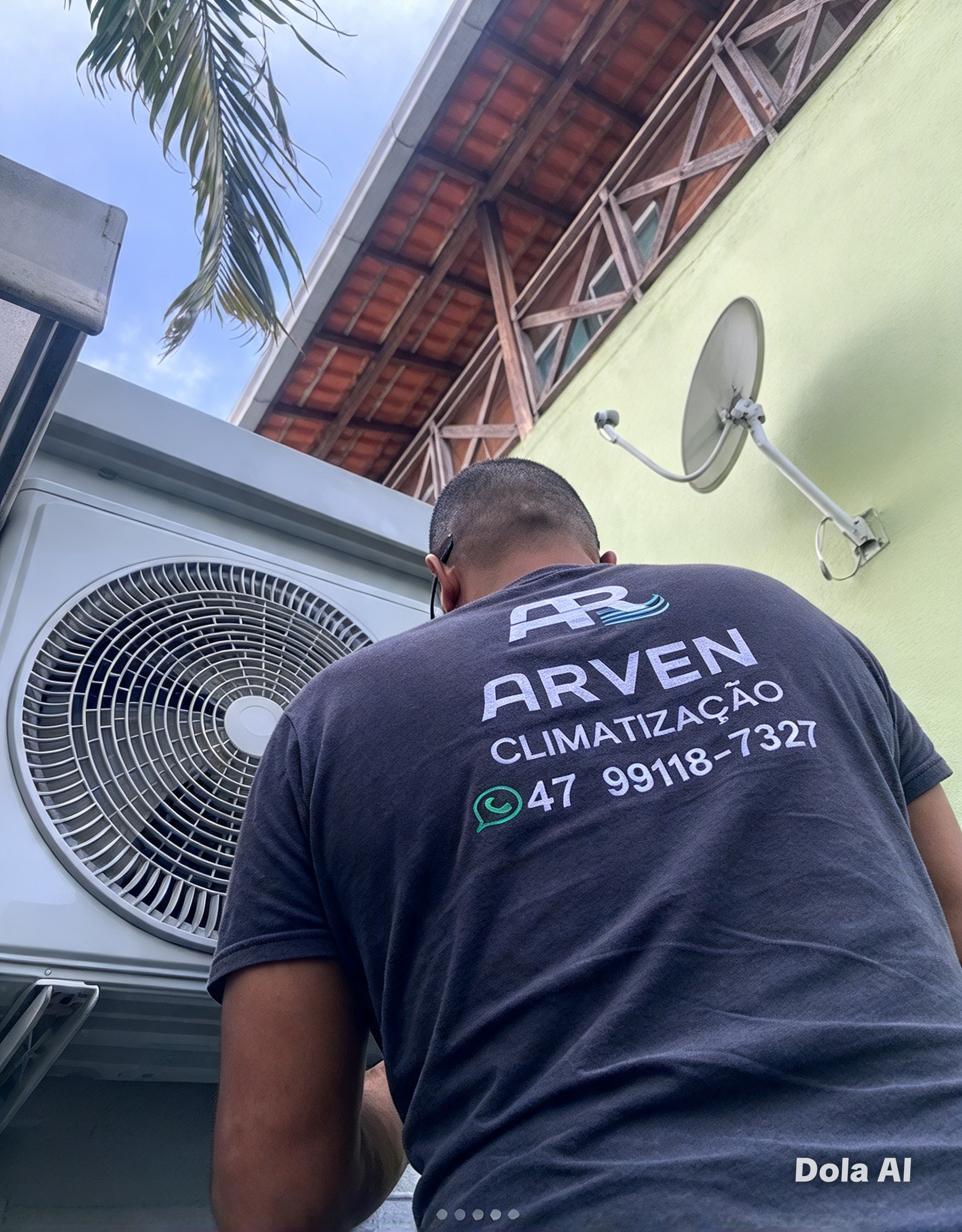 Técnico com camiseta da Arven Climatização trabalhando em uma unidade condensadora externa